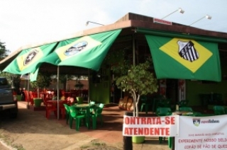 Bandeiras do Brasil com escudos de clubes ao centro também enfeitam o local.